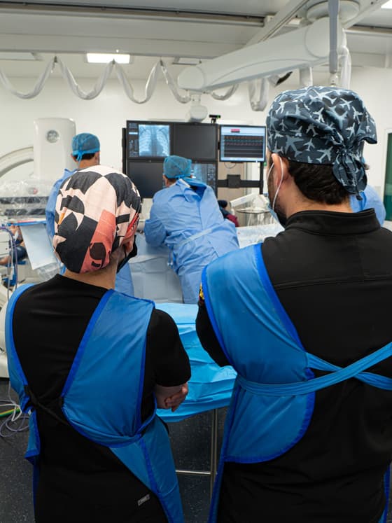 Sala de hemodinamia pediátrica con el equipo médico atendiendo un cateterismo cardiaco.