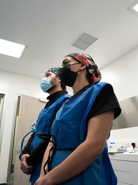 Los dos pediatras intensivistas con equipo de protección, listos para entrar a un procedimiento.