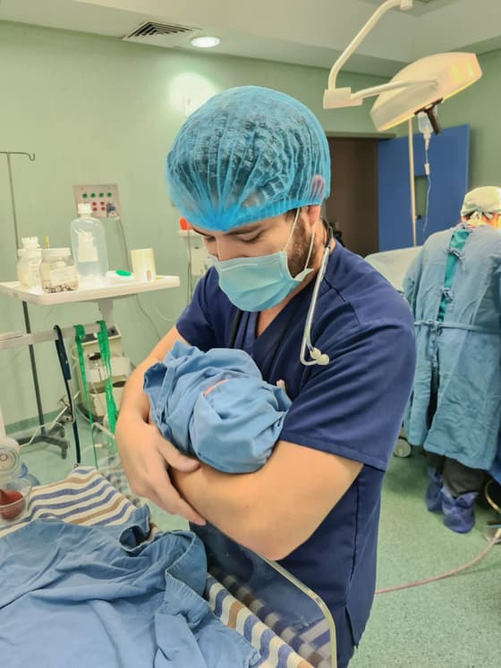 El Dr. Ramsés Zúñiga cargando a un recién nacido después de un procedimiento.