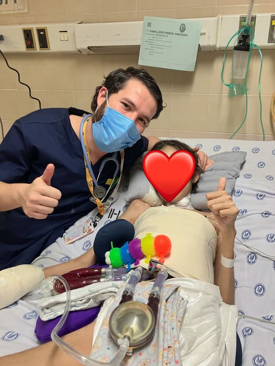 El Dr. Ramsés Zúñiga celebrando la mejoría de un paciente pediátrico junto a su cama.